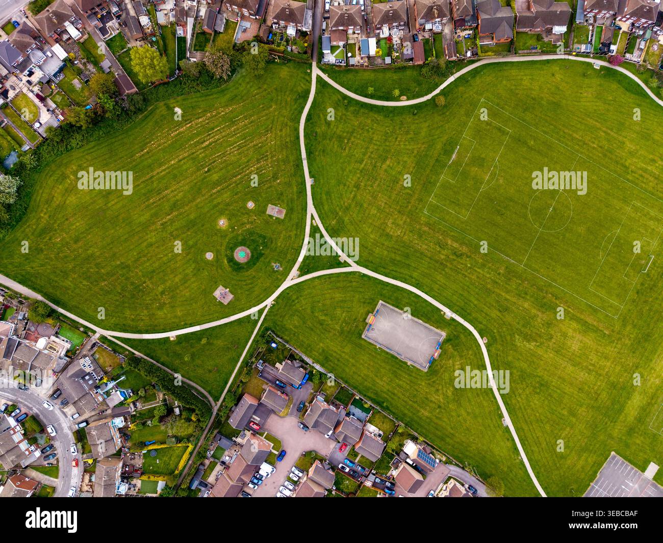 Vista dall'alto dall'alto sopra una tenuta residenziale suburbana nel Regno Unito con un campo da gioco e un parco Foto Stock