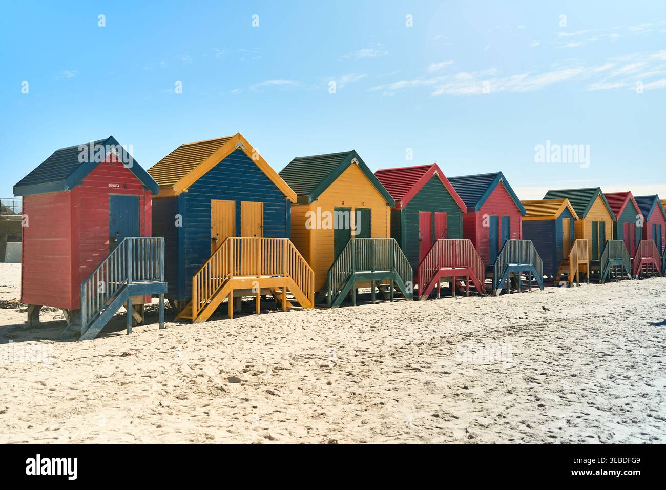 Cabine Vivid Seaside. Colorate capanne lungo la Sandy Coast. Ripari luminosi in legno sulla spiaggia con vista sulle montagne Foto Stock