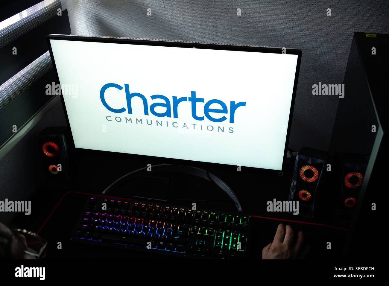 Persona alla scrivania con il logo aziendale Charter Communications visualizzato su un monitor del computer Foto Stock