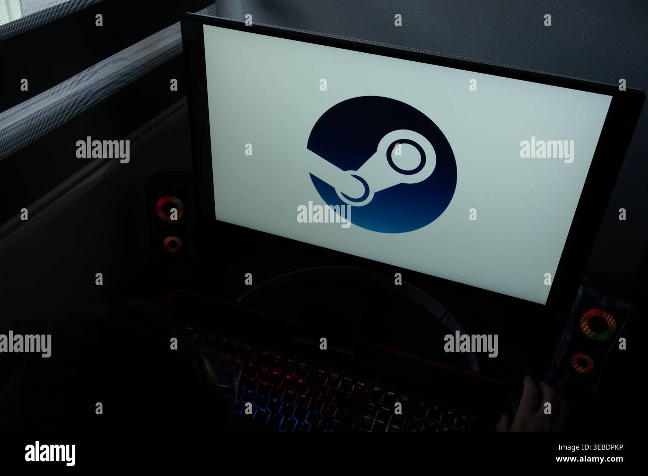 Il logo della piattaforma di distribuzione digitale dei videogiochi Steam viene visualizzato su un monitor del computer in una stanza buia Foto Stock