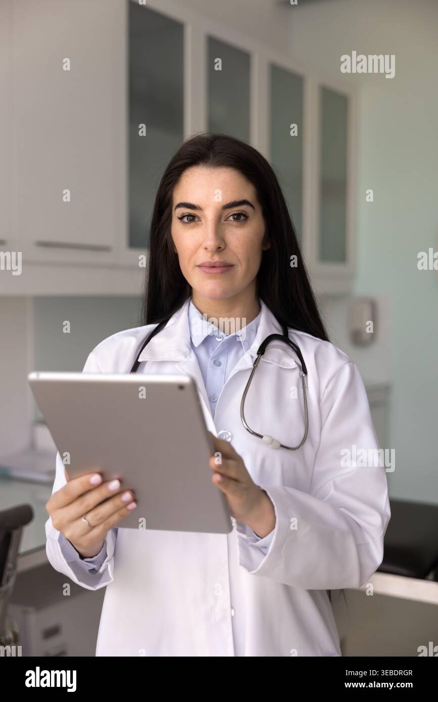 Ritratto di donna professionista sanitario che posa per la fotocamera con tablet Foto Stock