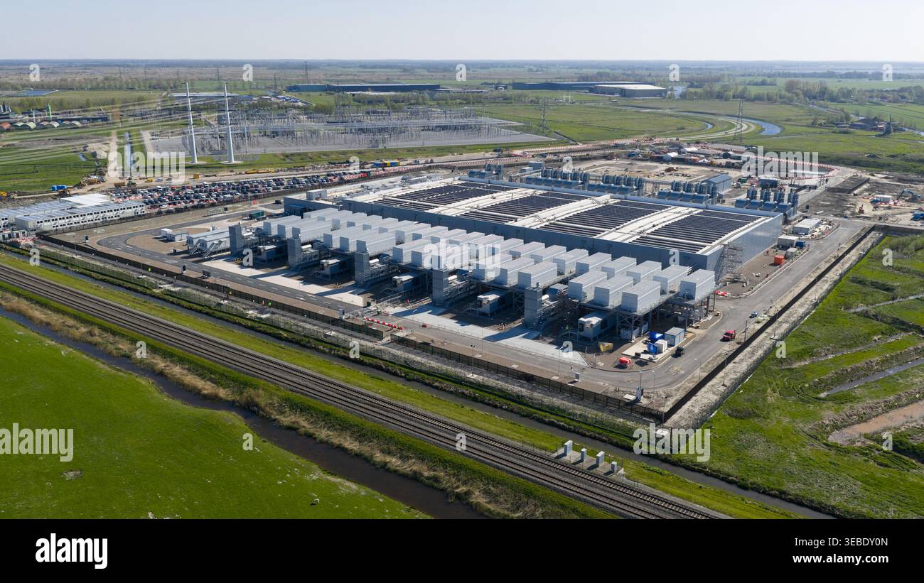 Veduta aerea del Datacenter Westpoort con la sua grande struttura industriale con unità di raffreddamento circondate da prati verdi e binari ferroviari a Groni Foto Stock