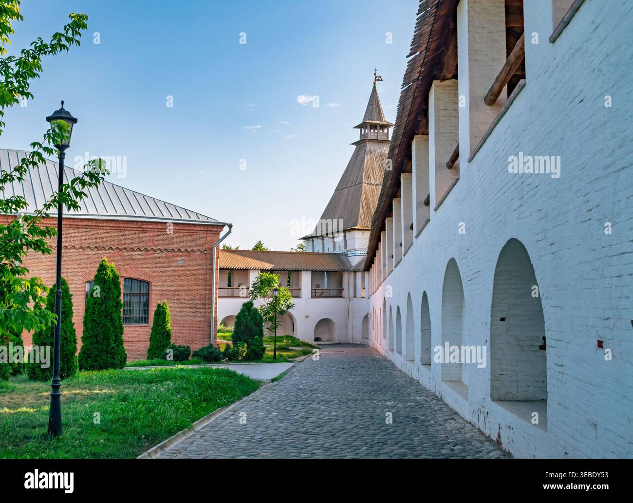 I giardini interni del Cremlino di Astrakhan in Russia mostrano storiche mura bianche, sentieri acciottolati e una struttura torreggiante in una giornata limpida Foto Stock