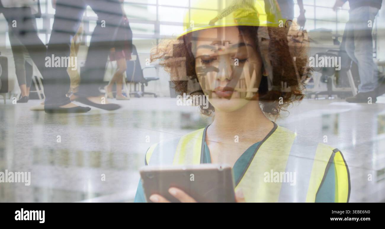 Tenendo in mano una donna tablet che indossa un giubbotto giallo ad alta visibilità che ispeziona la hall, con file di posti a sedere Foto Stock