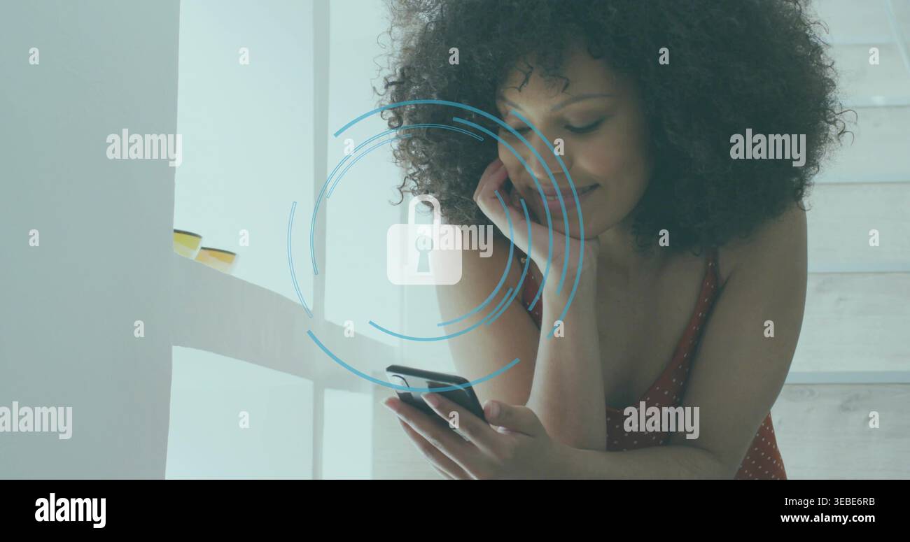 Donna pendente che indossa un abito rosso che controlla lo smartphone su una scala che atterra accanto alla finestra, con mascherina a lucchetto Foto Stock
