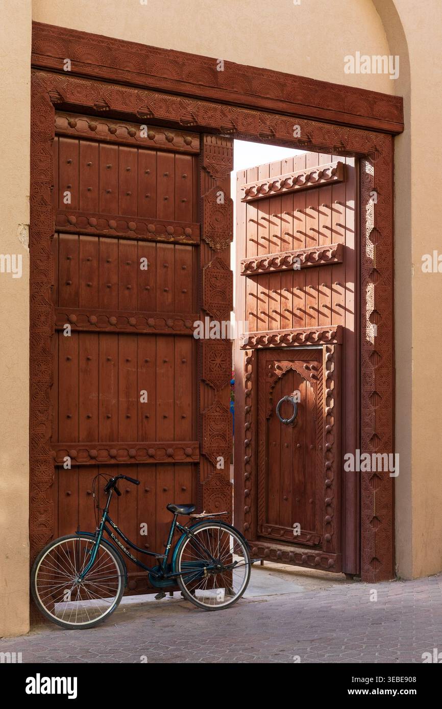 Porte d'ingresso splendidamente intagliate e ornate dell'Ufficio postale dell'Oman presso il Souq centrale di Nizwa, Oman Foto Stock