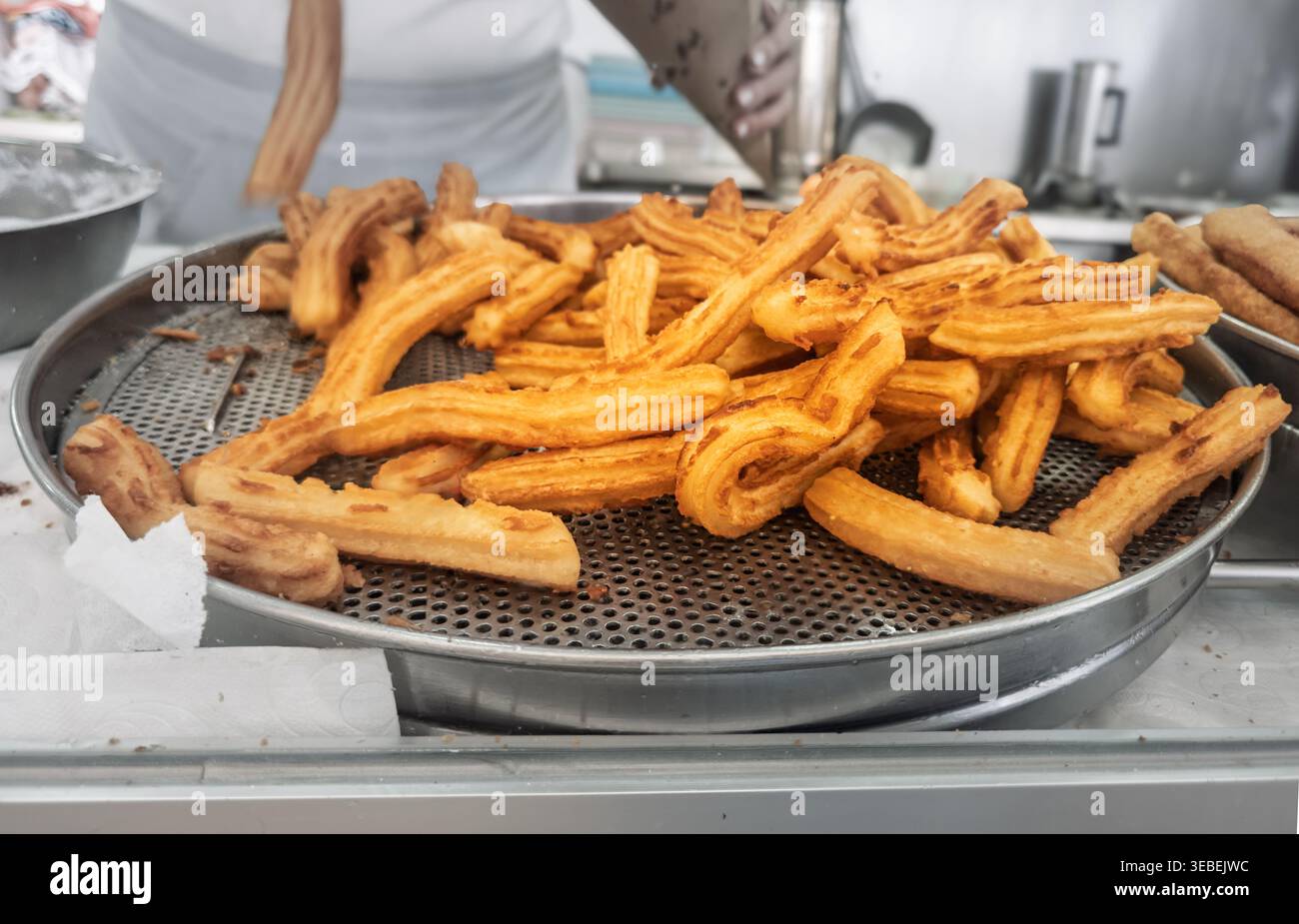 Churros appena fritti in uno stand di cibo di strada che si asciuga Foto Stock