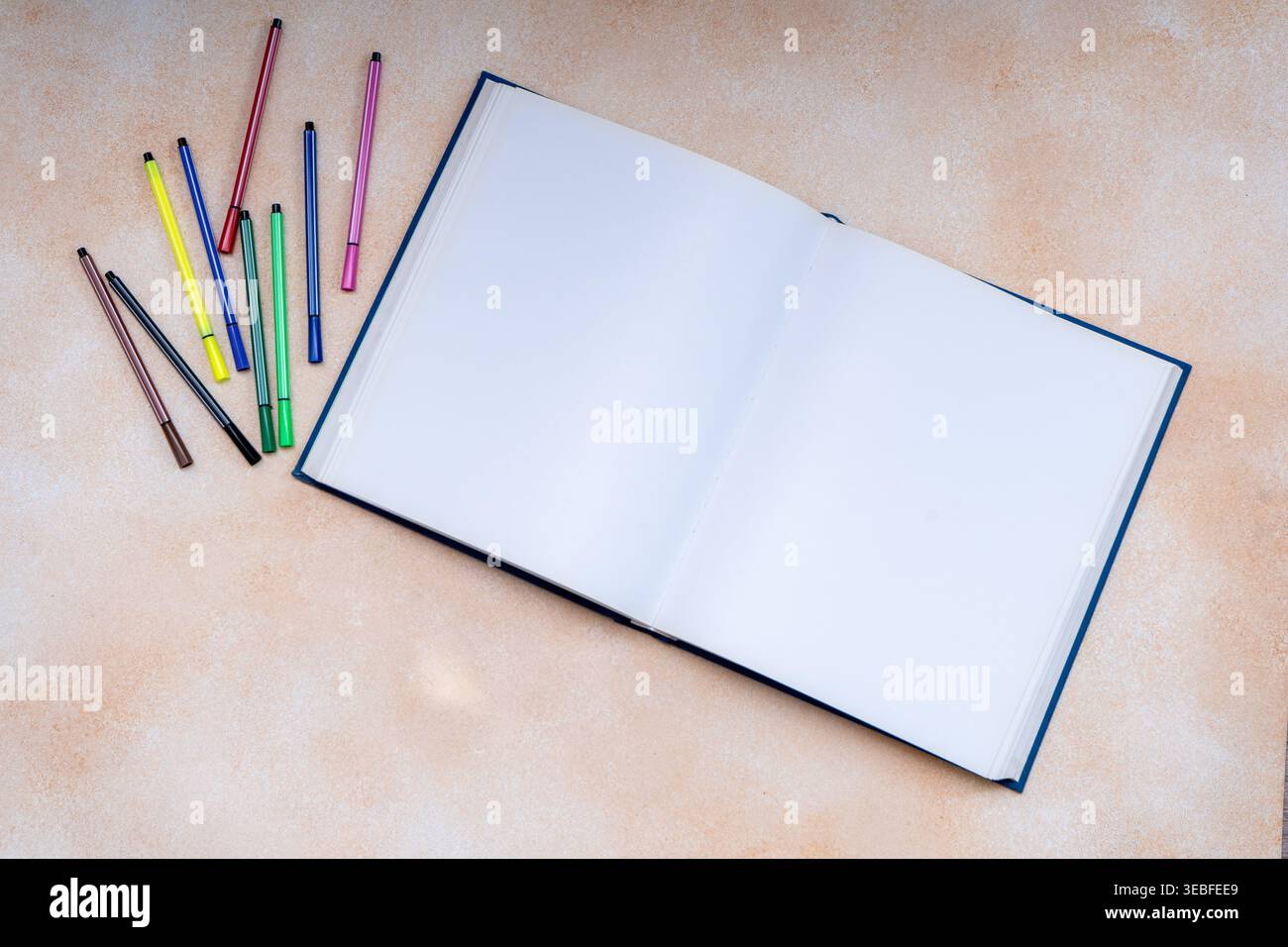 Aprire il libro Sketch con la vista superiore dei marcatori colorati sfondo dello spazio di copia. Foto Stock