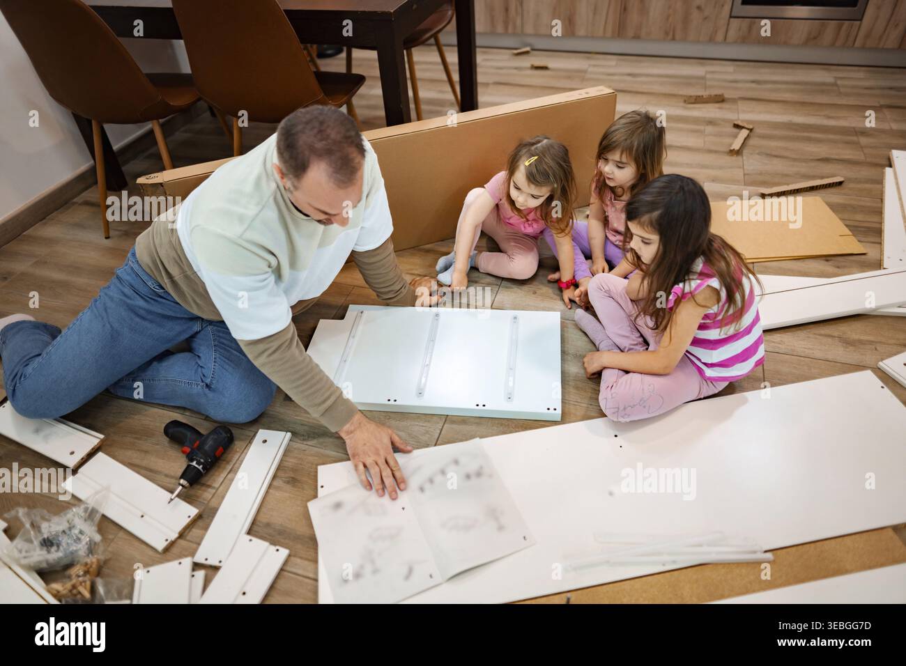 Momenti creativi di assemblaggio con la famiglia in un accogliente soggiorno Foto Stock