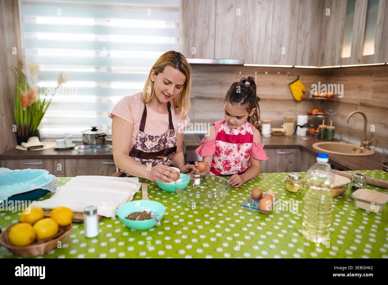 Cucinare gioia con madre e figlia in una cucina accogliente Foto Stock
