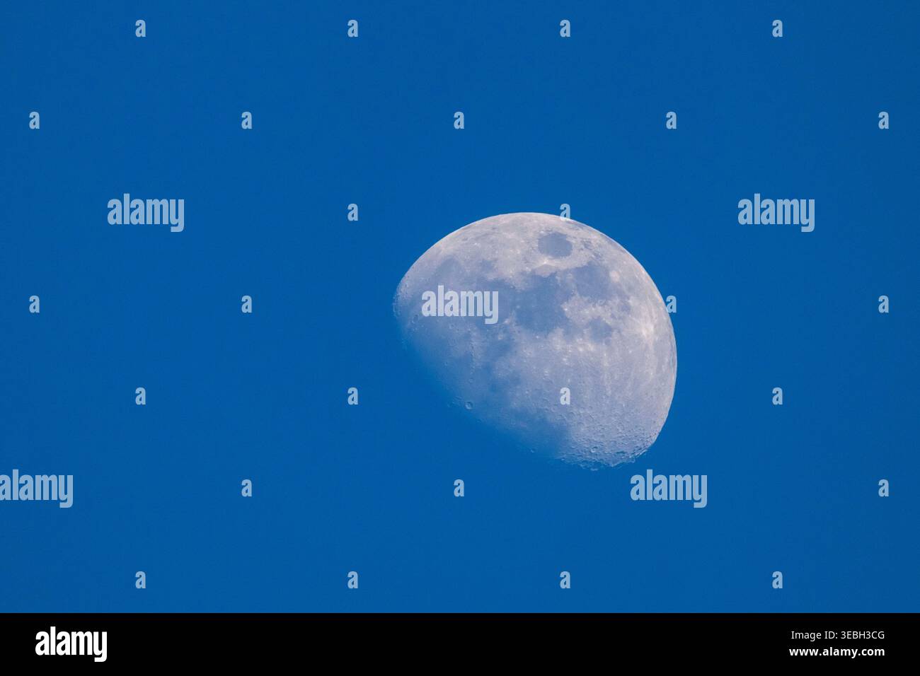 Foto della luna di tre quarti di cera contro il cielo blu diurno Foto Stock