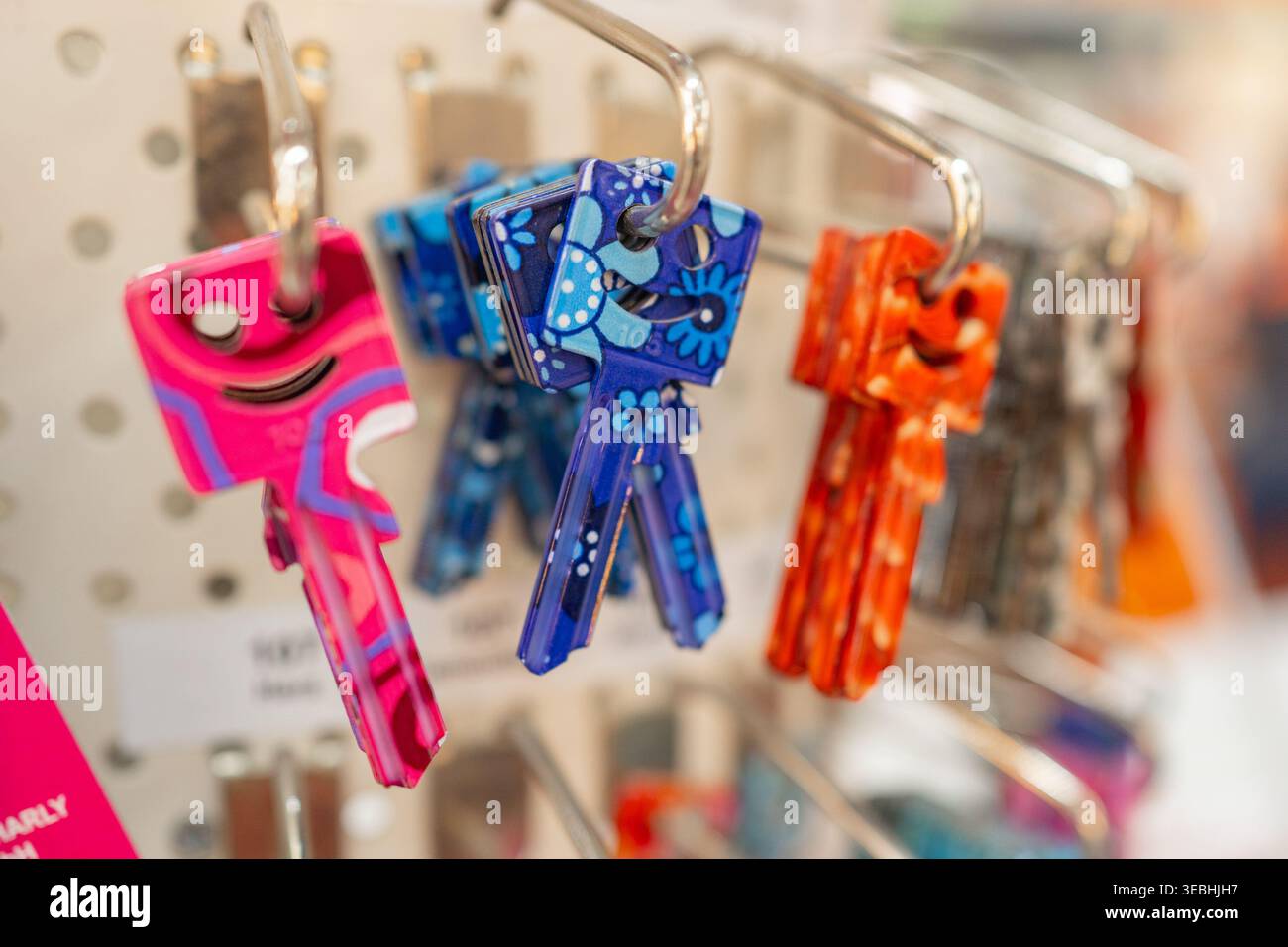 Primo piano di duplicati colorati appesi in un negozio. Varietà di forme e colori che rappresentano i servizi di fabbro e le soluzioni di sicurezza. Foto Stock