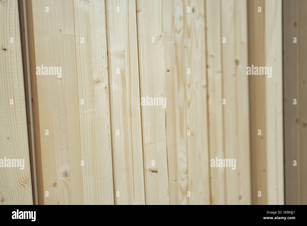 Primo piano di pannelli verticali in legno a grana naturale. Rivestimento decorativo utilizzato negli interni, con linee pulite e texture organiche calde. Foto Stock