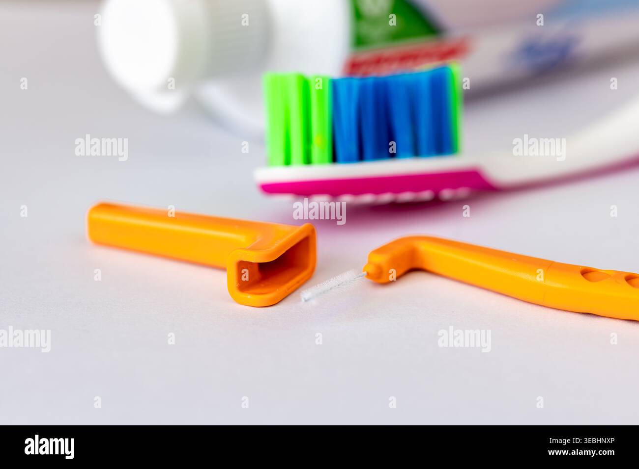 Primo piano di uno spazzolino interdentale angolare, uno spazzolino da denti e una pasta da denti isolata sul bianco. Foto Stock