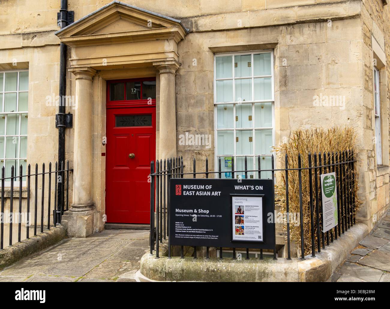 L'ingresso al Museum of East Asian Art in uno storico edificio in pietra calcarea con una porta rossa luminosa e dettagli architettonici classici Bath UK Foto Stock