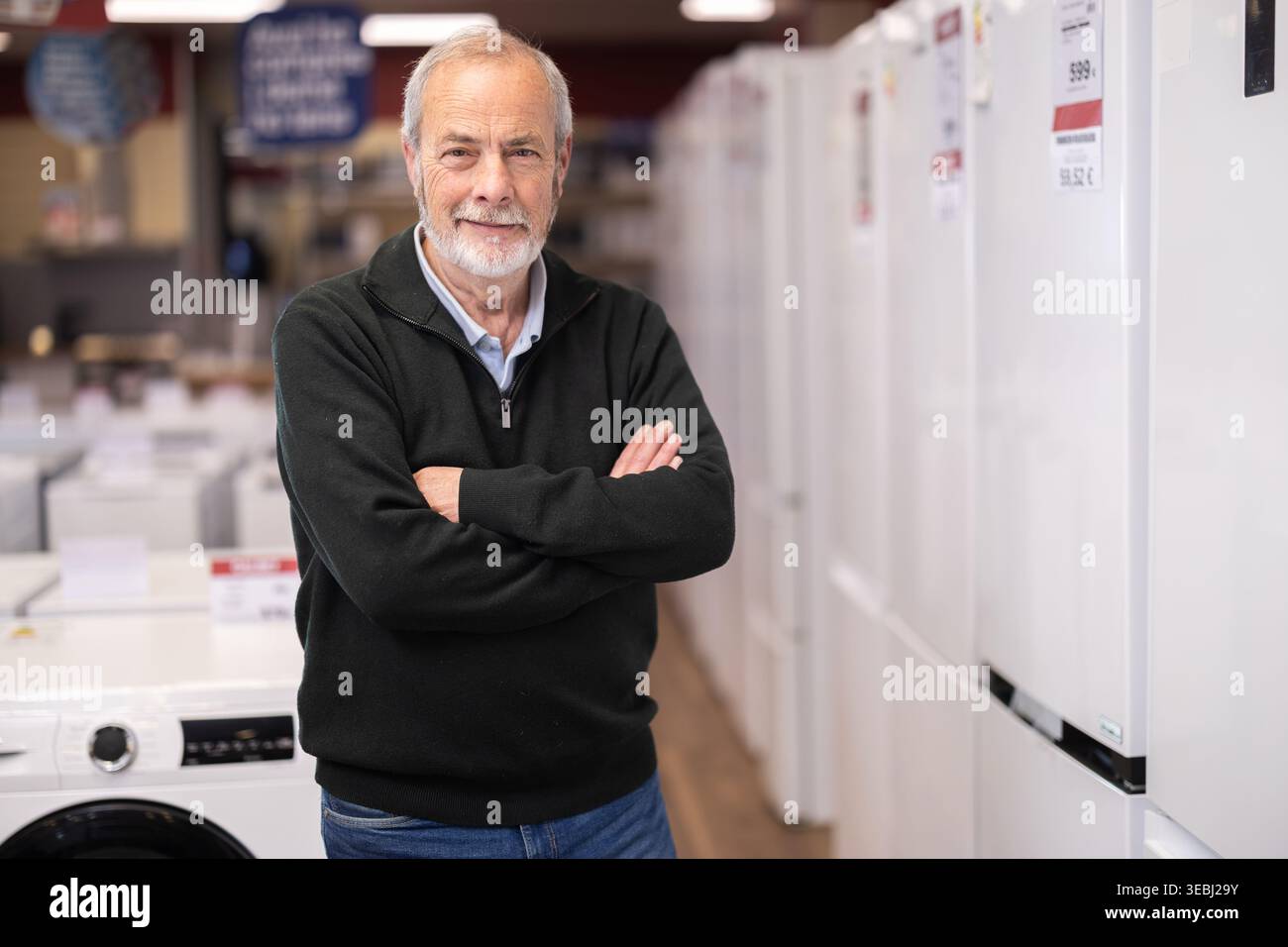 Gli anziani scelgono un frigo moderno al supermercato Foto Stock