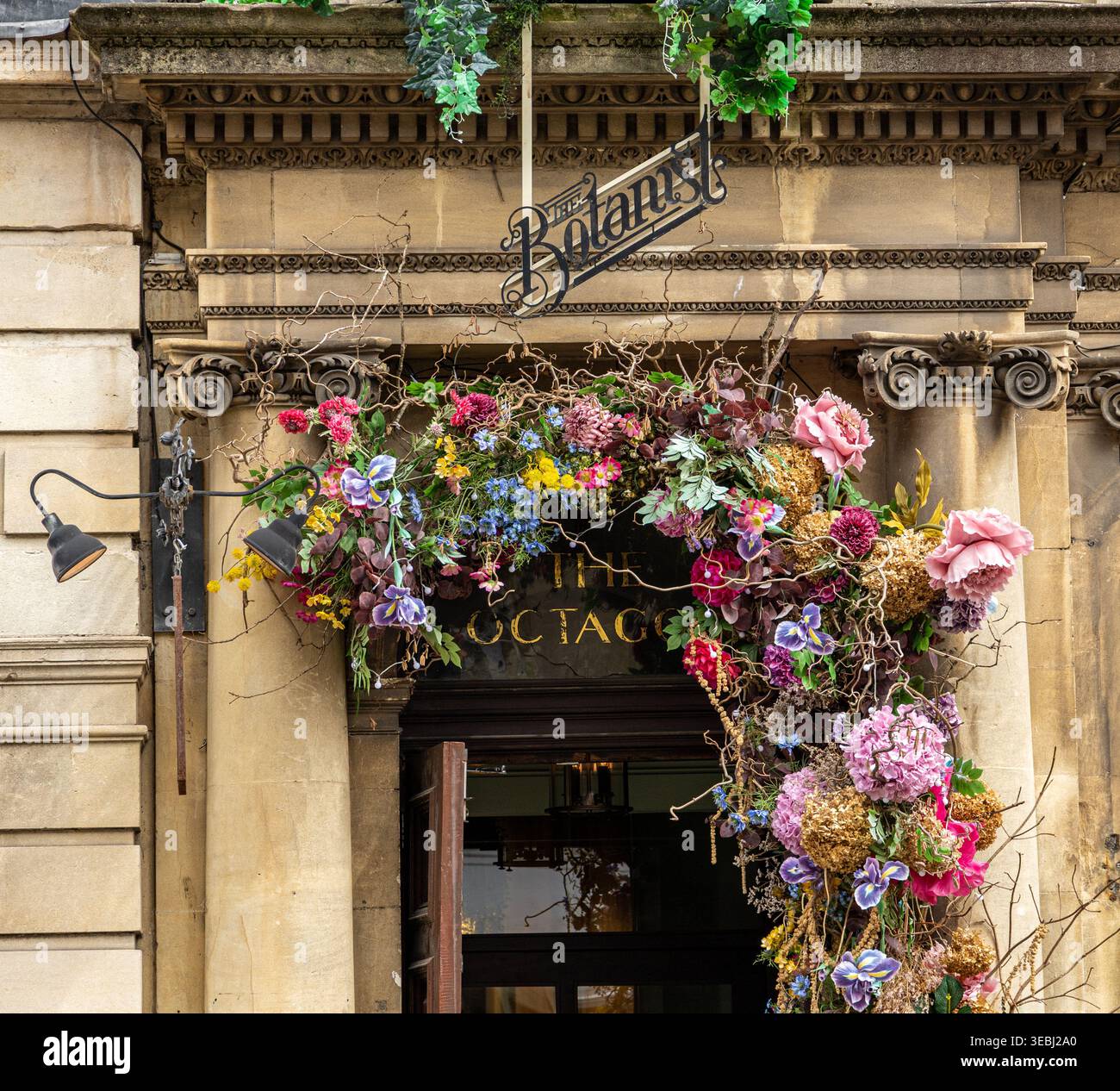Elegante entrata del ristorante botanico Milsom Street Bath adornato con colorate decorazioni floreali su una classica facciata di edificio in pietra Foto Stock