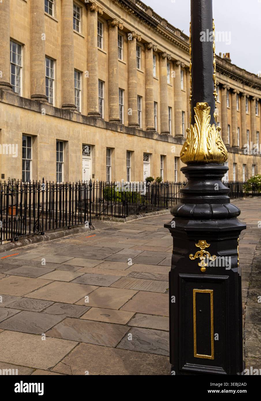 Elegante architettura georgiana nel Royal Crescent Bath caratterizzata da un grande edificio a mezzaluna curvo e da un'ornata lampada da strada in primo piano Foto Stock