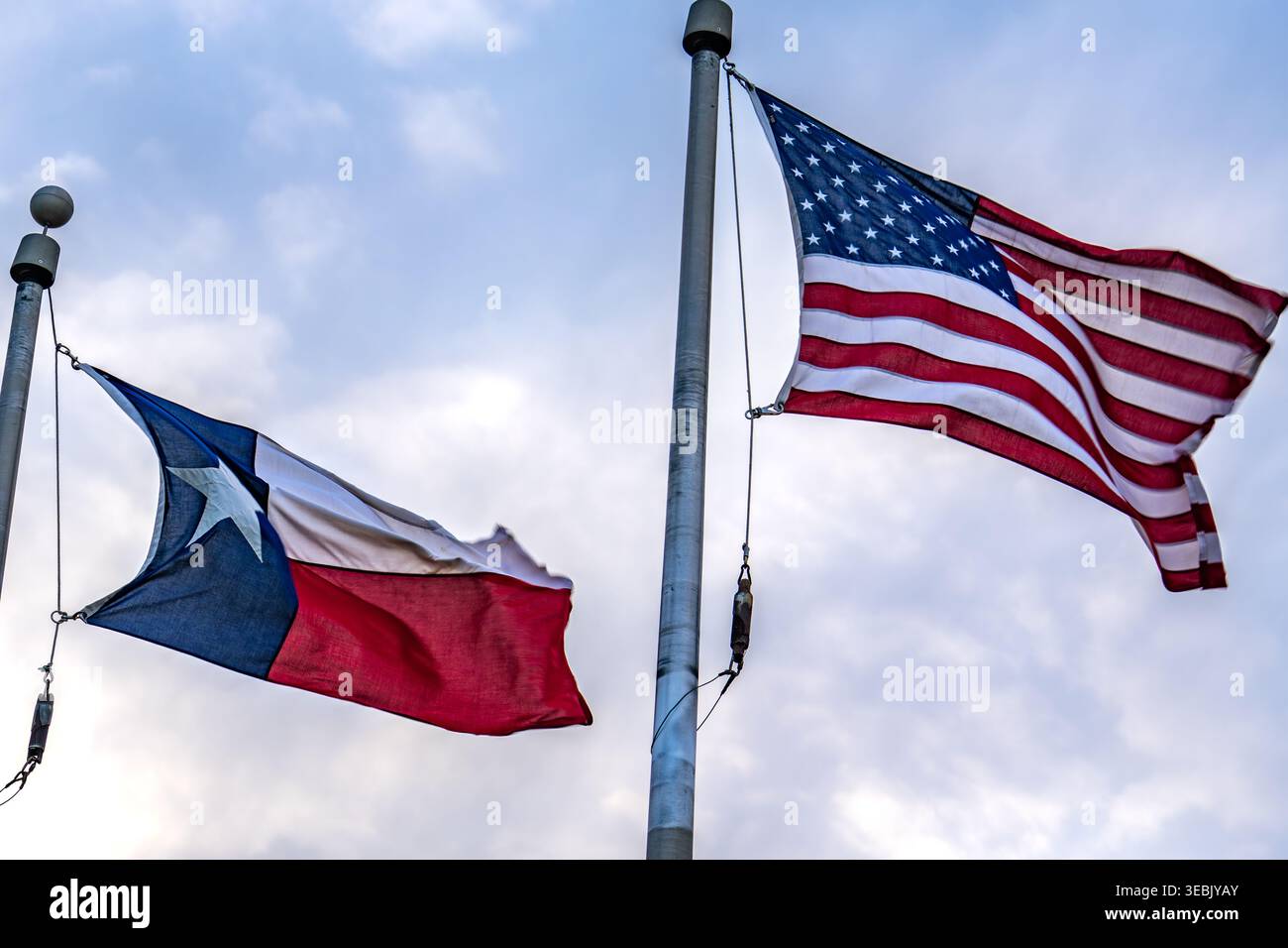 Grapevine, Texas, Stati Uniti - 17 aprile 2025: Bandiera americana e bandiera del Texas soffiano in forte brezza Foto Stock