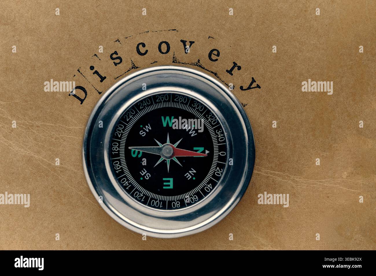 Stampigliatura DISCOVERY con bussola magnetica. Concetto trovare nuove conoscenze o segreti nascosti Foto Stock