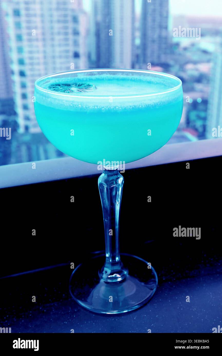 Cocktail surreale pop art color acqua blu sul tavolo del bar sul tetto Foto Stock