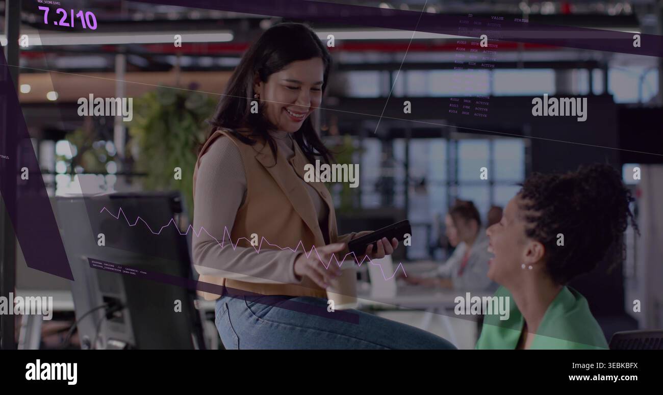 Donna sorridente seduta all'estremità della scrivania con telefono e tazza, blazer verde che ride, rivestimento viola Foto Stock
