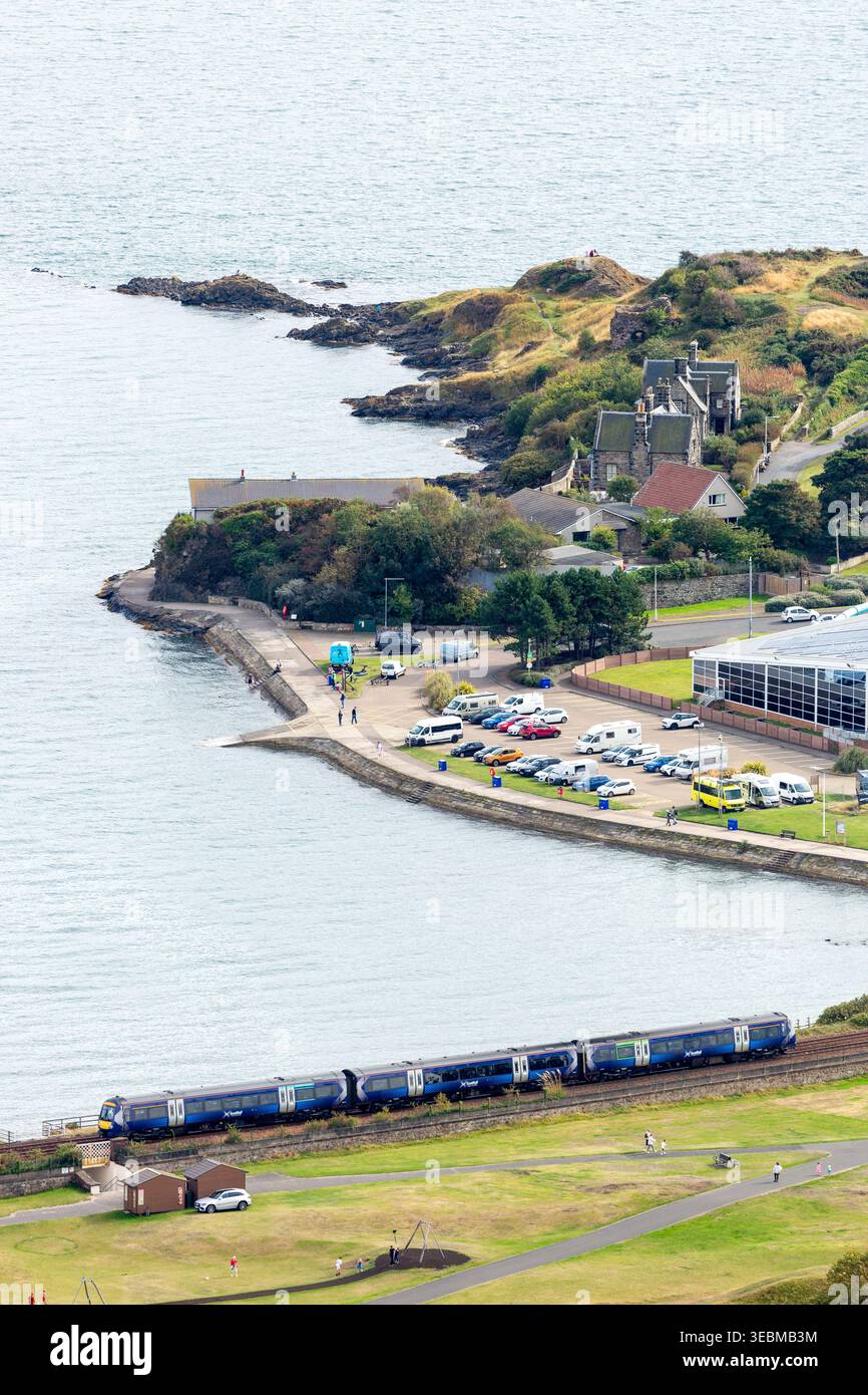 Un treno che viaggia lungo la costa di Burntisland visto dall'alto, Fife, Scozia Foto Stock