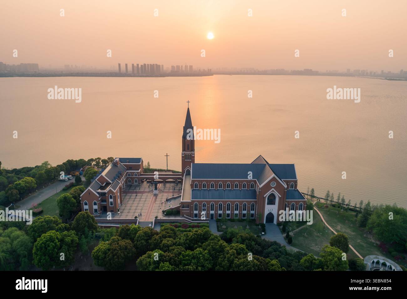 Chiesa del Lago Dushu a Suzhou in piedi orgogliosamente vicino all'acqua tranquilla al tramonto Foto Stock