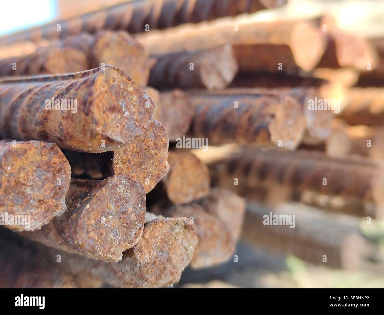 Primo piano delle estremità dei perni in acciaio arrugginito raggruppate tra loro, che mostrano la corrosione dettagliata e la consistenza del metallo ruvido nel cantiere. Materiali da costruzione, metallo Foto Stock