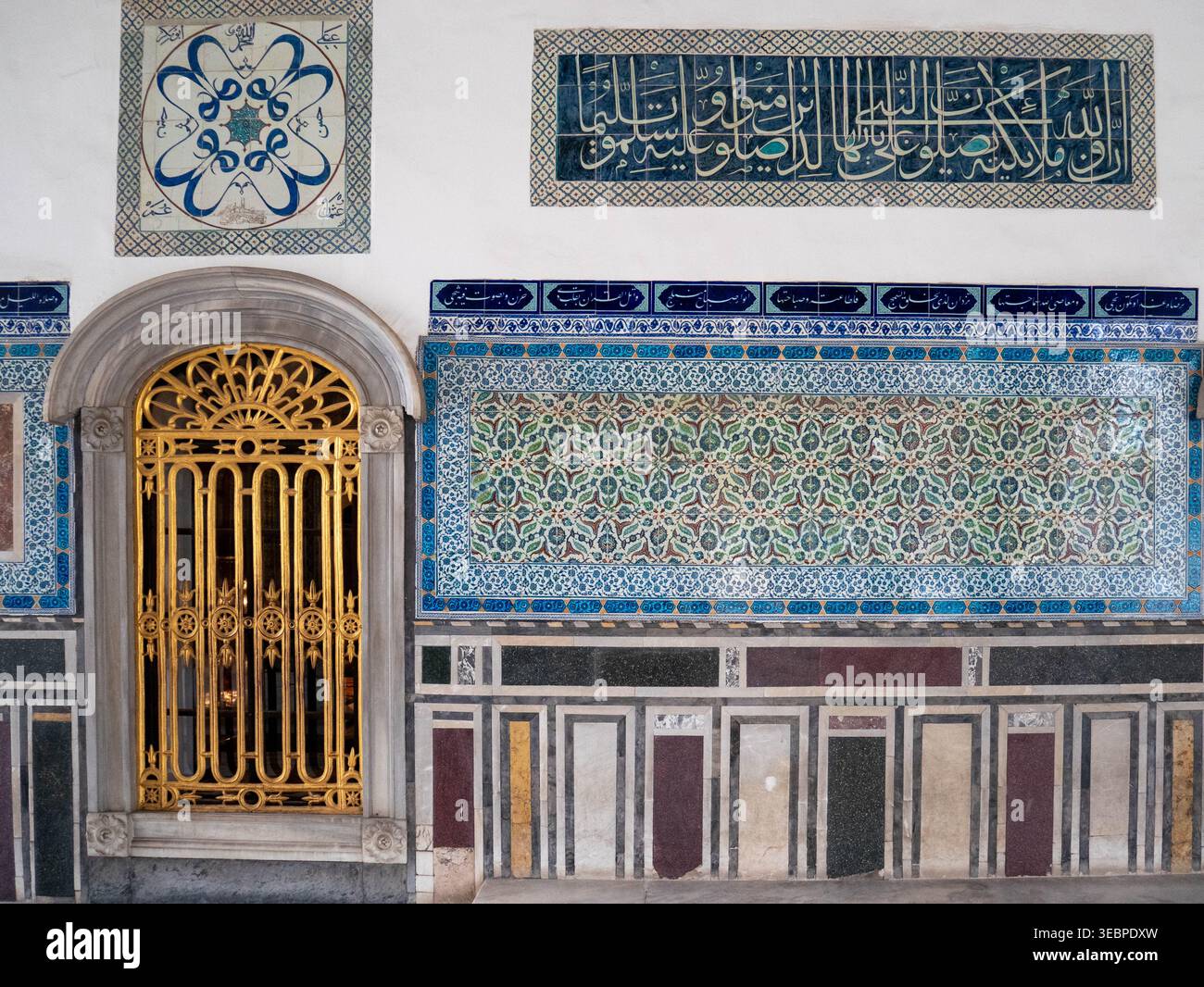 Le intricate piastrelle ottomane e la calligrafia araba dorata adornano le pareti dello storico Palazzo Topkapi e dell'Harem a Istanbul, in Turchia, sotto una luce soffusa Foto Stock