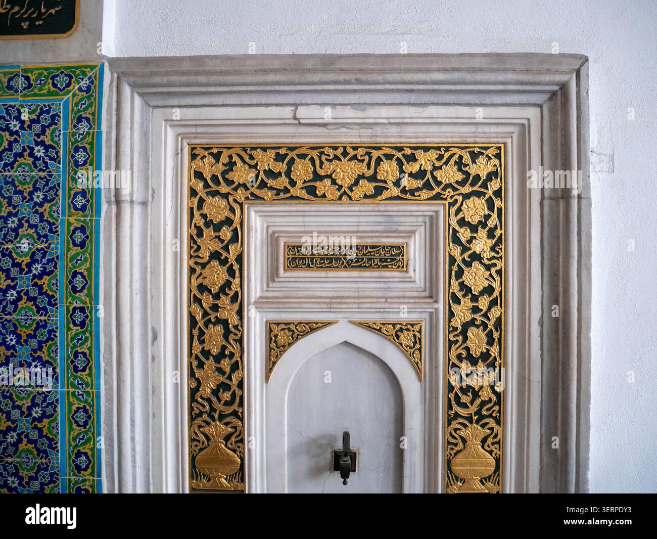 Le intricate piastrelle ottomane e la calligrafia araba dorata adornano le pareti dello storico Palazzo Topkapi e dell'Harem a Istanbul, in Turchia, sotto una luce soffusa Foto Stock