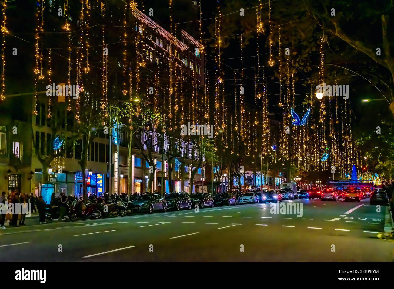 Barcellona, Spagna - 26 novembre 2021: Capodanno acceso e ghirlande natalizie sulla strada con auto in via Paseo de Gracia a Barcellona al crepuscolo Foto Stock