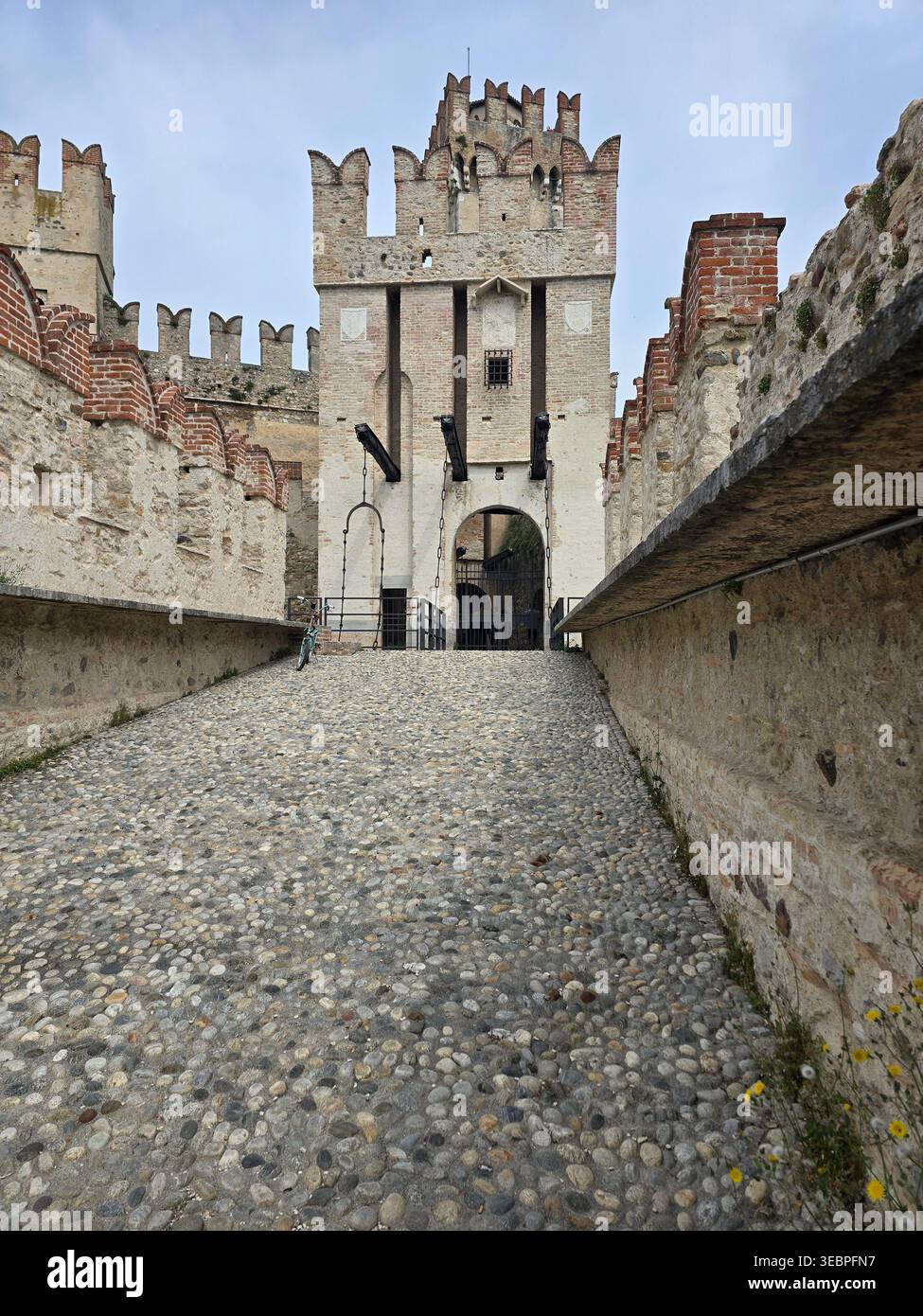 Vista ad angolo basso della porta medioevale del ponte levatoio, Castello Scaligero, Sirmione, Lago di Garda, Lombardia, Italia. Maggio 2025. - Immagine stock catturata con smartphone