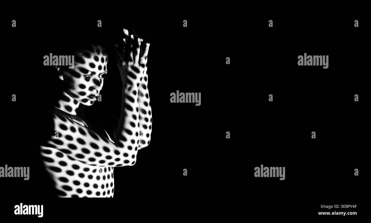Espressione creativa attraverso la luce e l'ombra nelle prestazioni artistiche di un modello Foto Stock