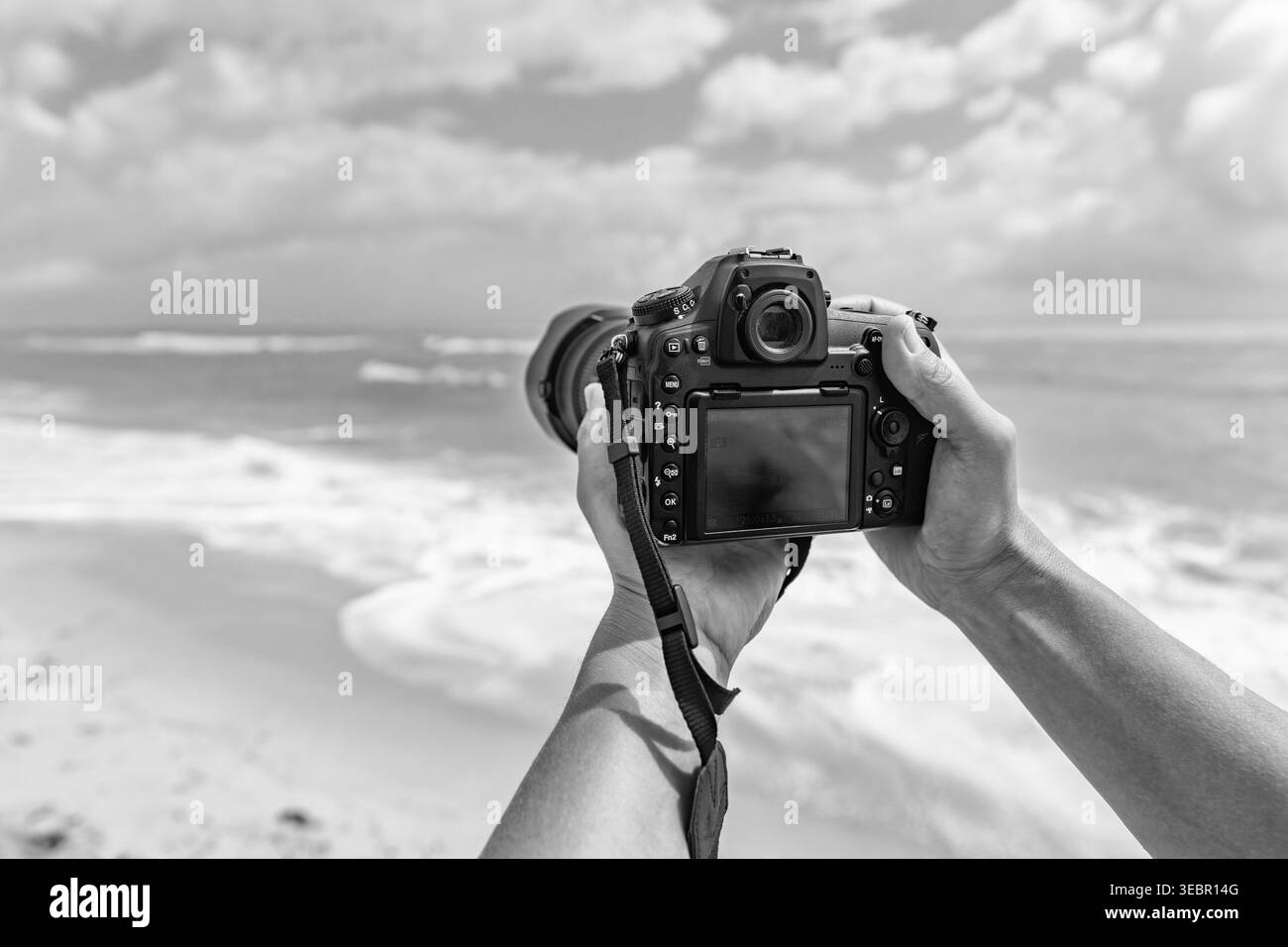 Vacanze estive al mare. Viaggi e fotografia. Fotografo che fa foto con la fotocamera. Viaggiatore con macchina fotografica sulla spiaggia estiva. Fotografia di viaggio Foto Stock