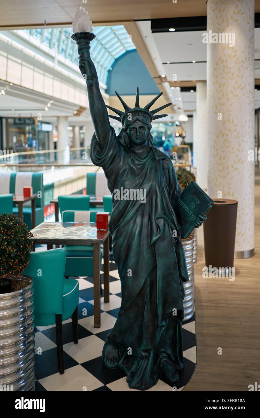 Una replica a grandezza naturale della Statua della libertà all'interno di una caffetteria a tema. Ristorante dall'arredo creativo in stile americano in un moderno centro commerciale o plaza Foto Stock