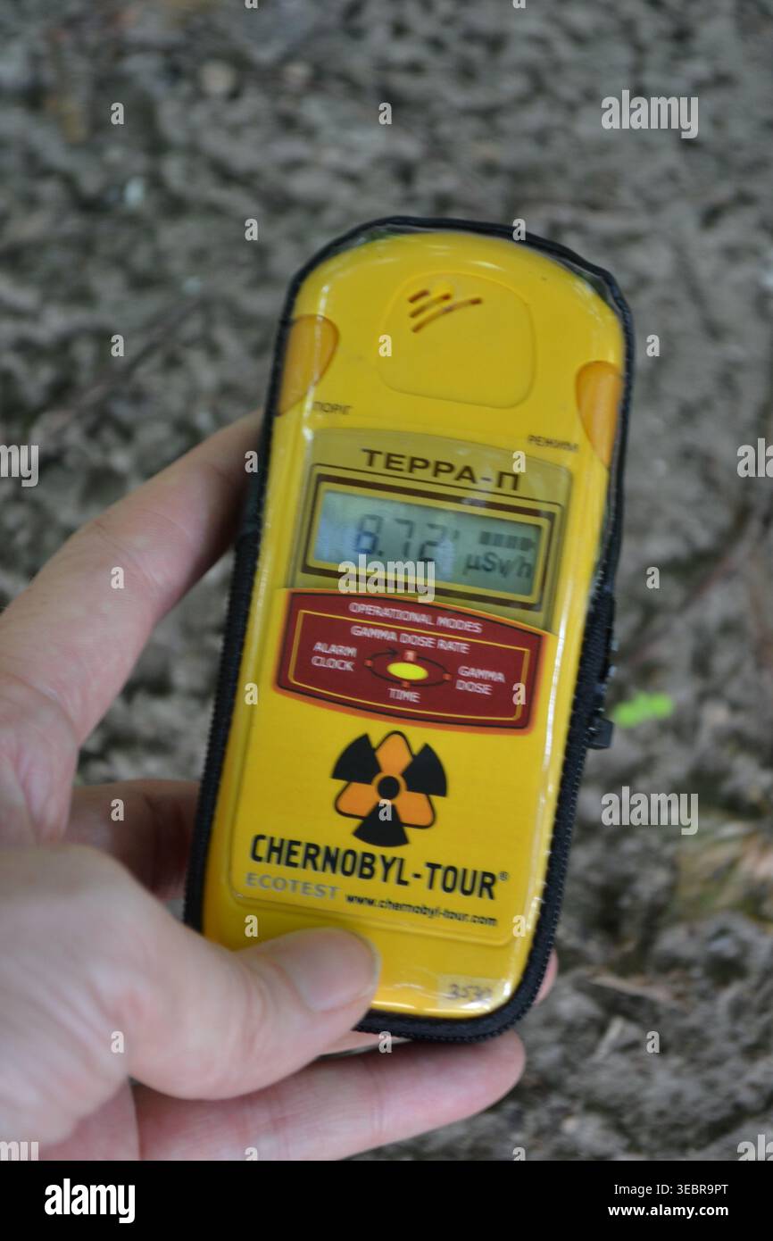 Il dosimetro mostra radiazioni estreme su un punto caldo terrestre nella zona di esclusione di Chernobyl, Ucraina, evidenziando una contaminazione elevata e pericolosa. Foto Stock
