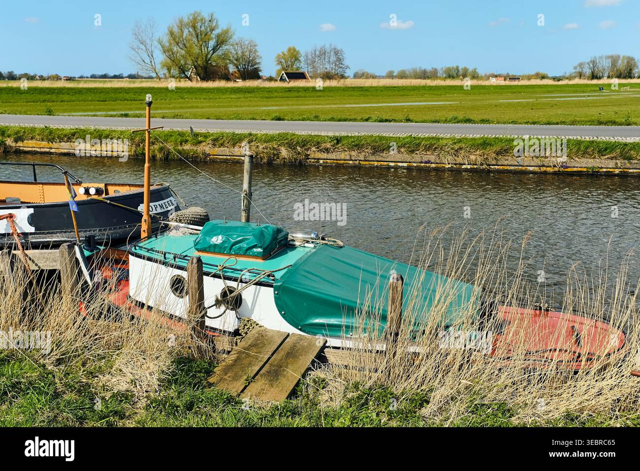Corsi d'acqua olandesi e fascino rurale il rimorchiatore di Pusher ormeggiato lungo Un canale nella pittoresca campagna dei canali olandesi e il fascino rurale Foto Stock