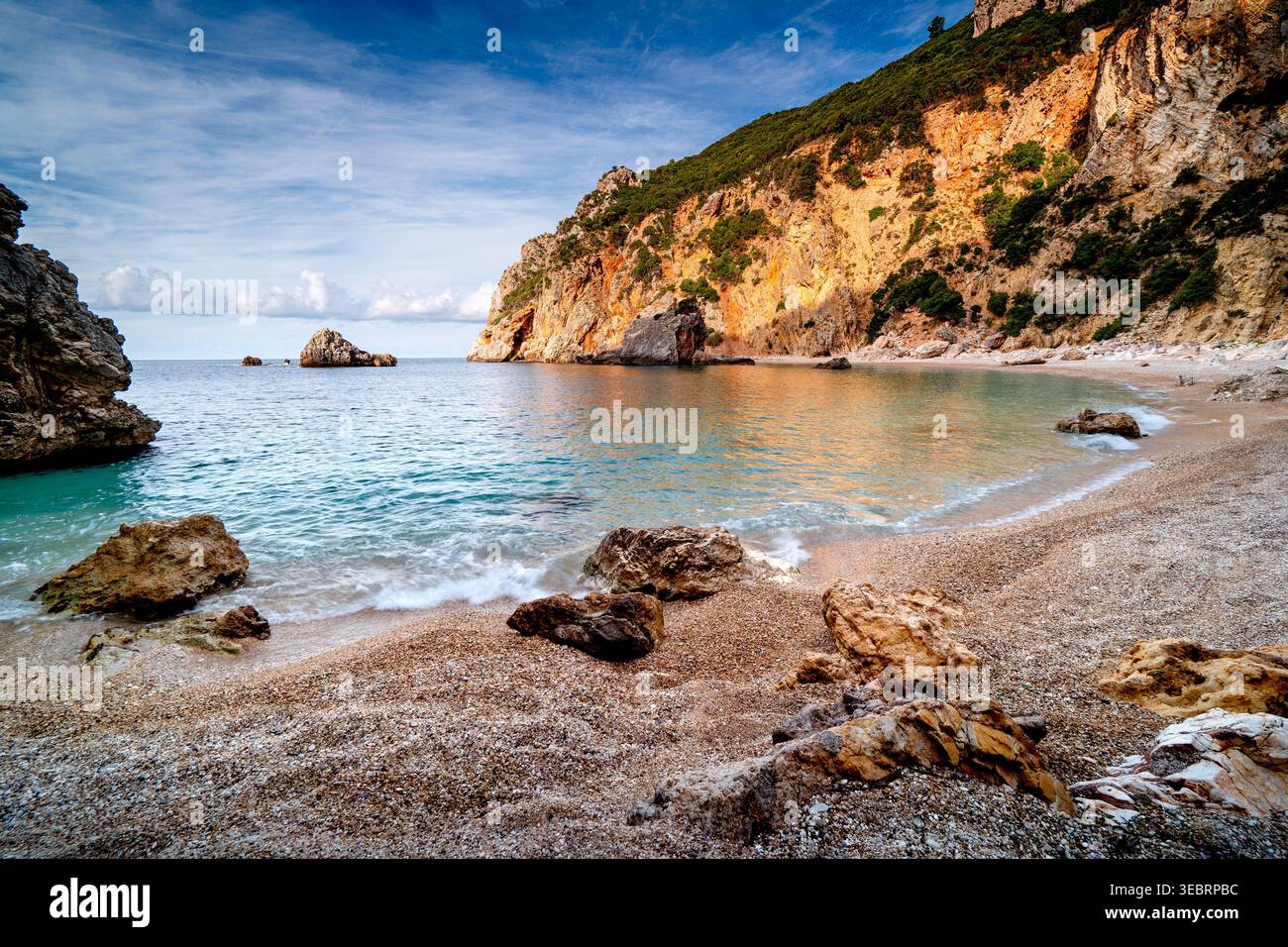 La spiaggia selvaggia di Gyali sull'isola di Corfù al mattino, sfondo di vacanza greca con scogliere. Foto Stock