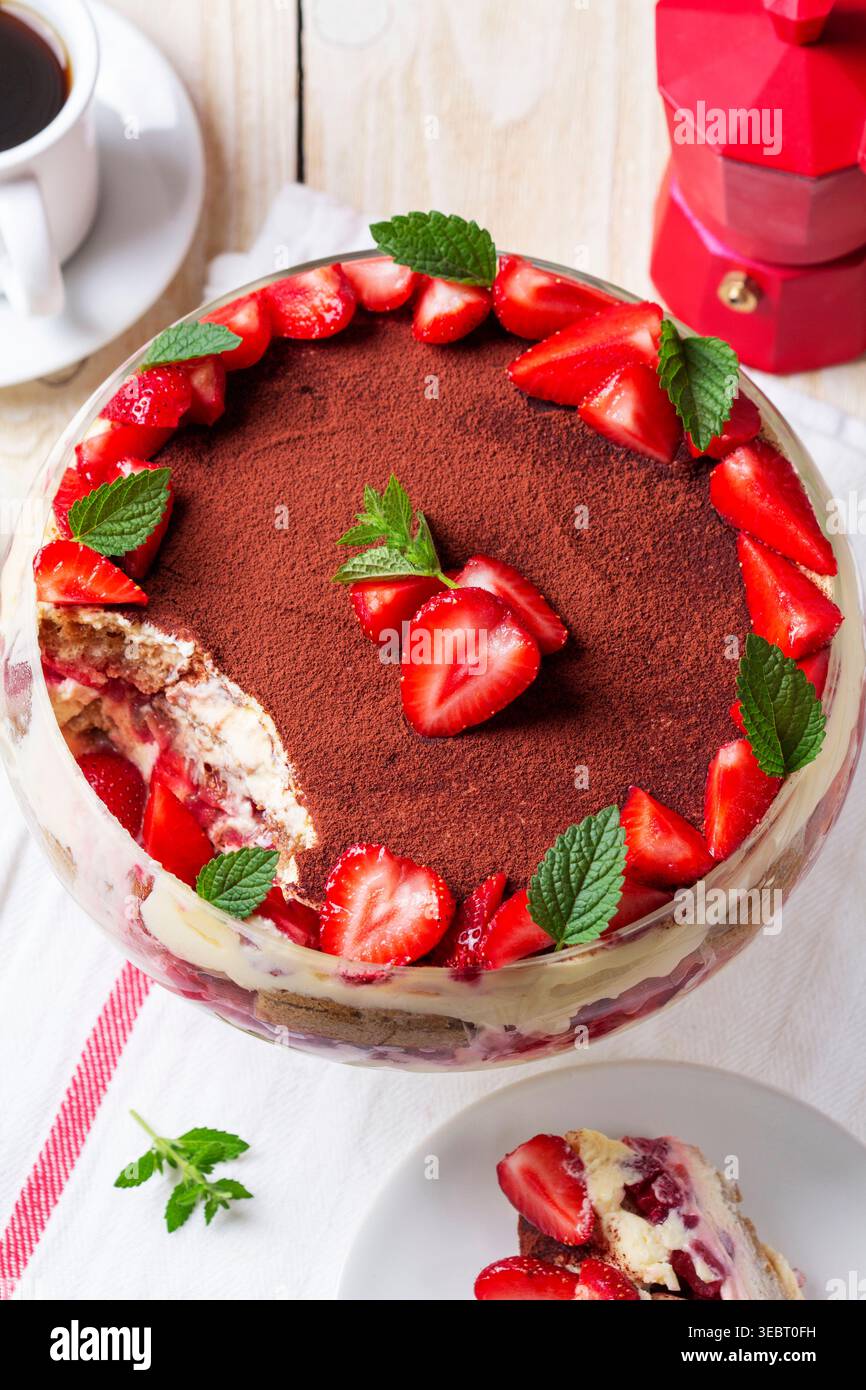 Dessert trifle alla fragola con strati di crema e menta in ciotola di vetro Foto Stock