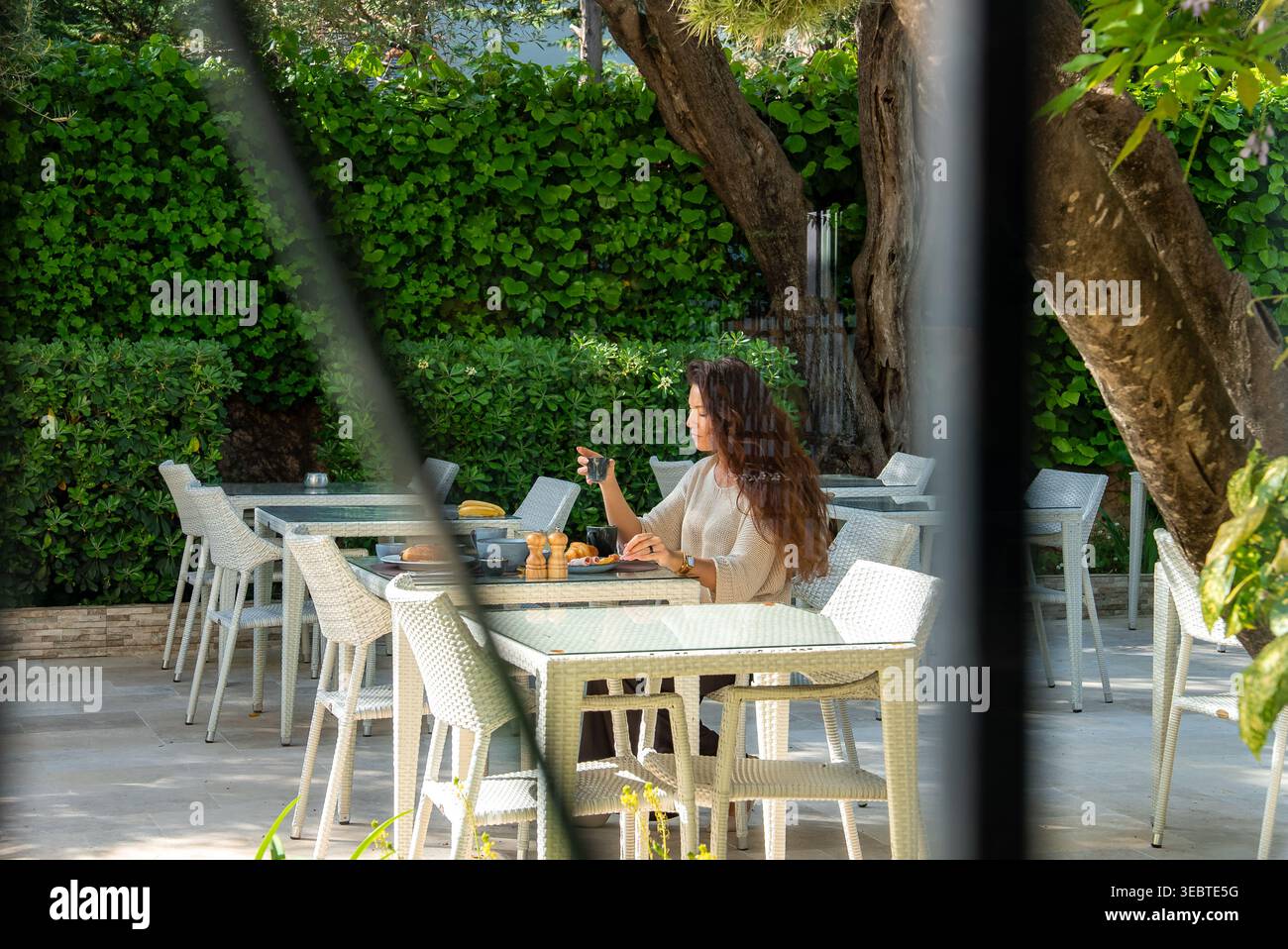 Caffetteria mattutina nel cortile giardino di Antibes con dolci e frutta Foto Stock