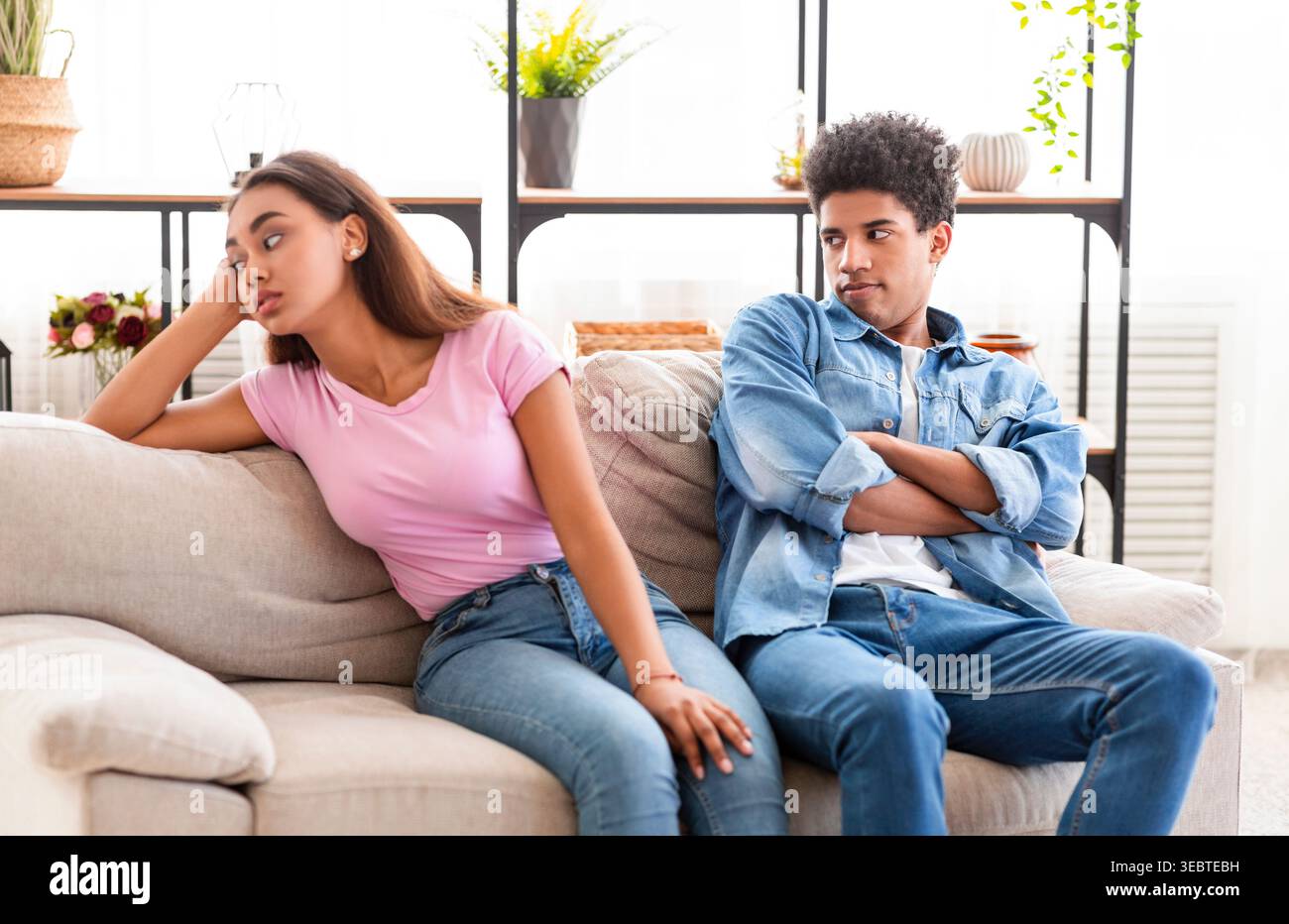 Coppia seduta su un divano per una conversazione tesa in un accogliente soggiorno Foto Stock