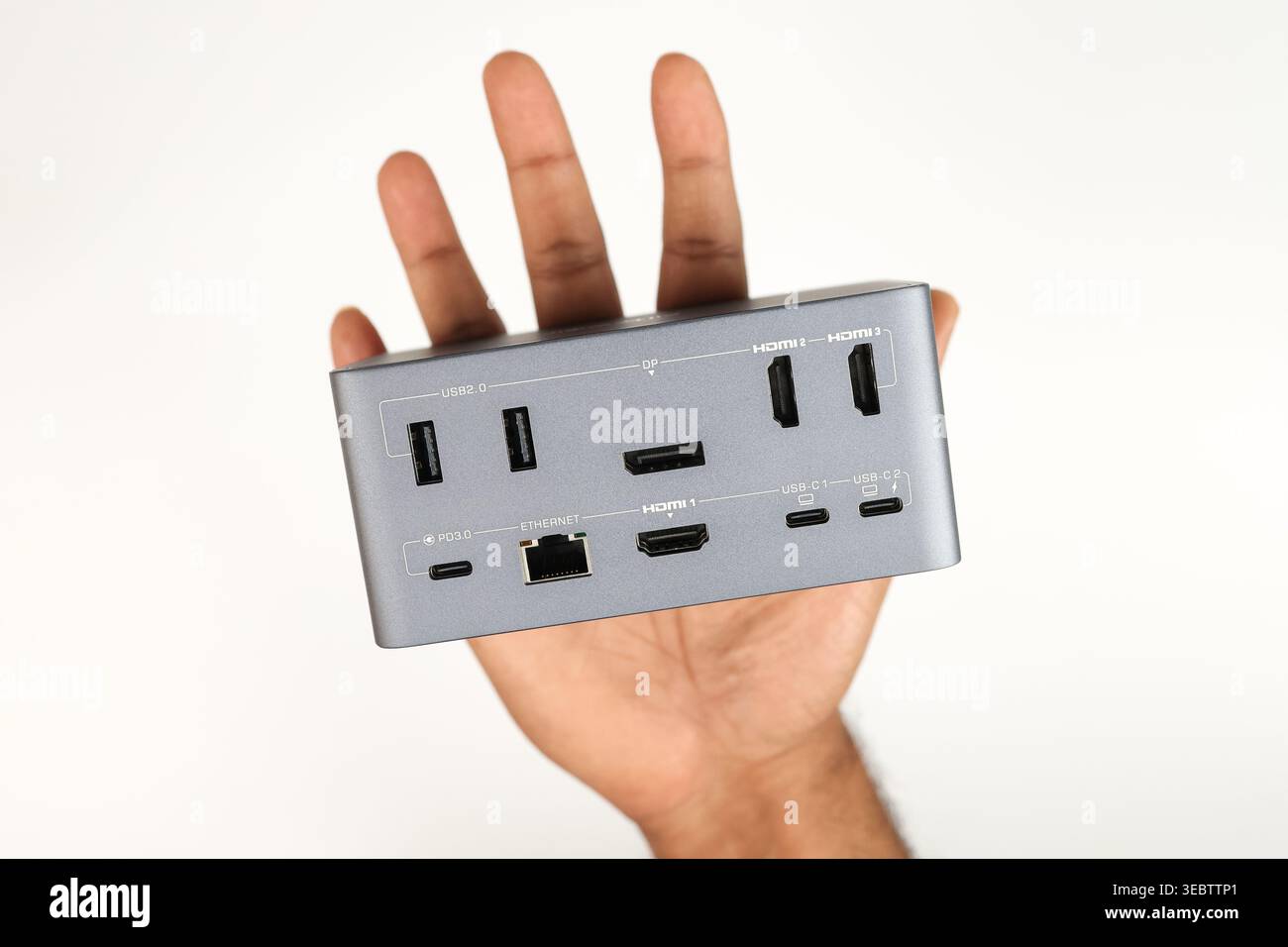 Lato posteriore di una docking station con porte HDMI, TypeC in mano isolate su sfondo bianco (concetto di connettività) Foto Stock