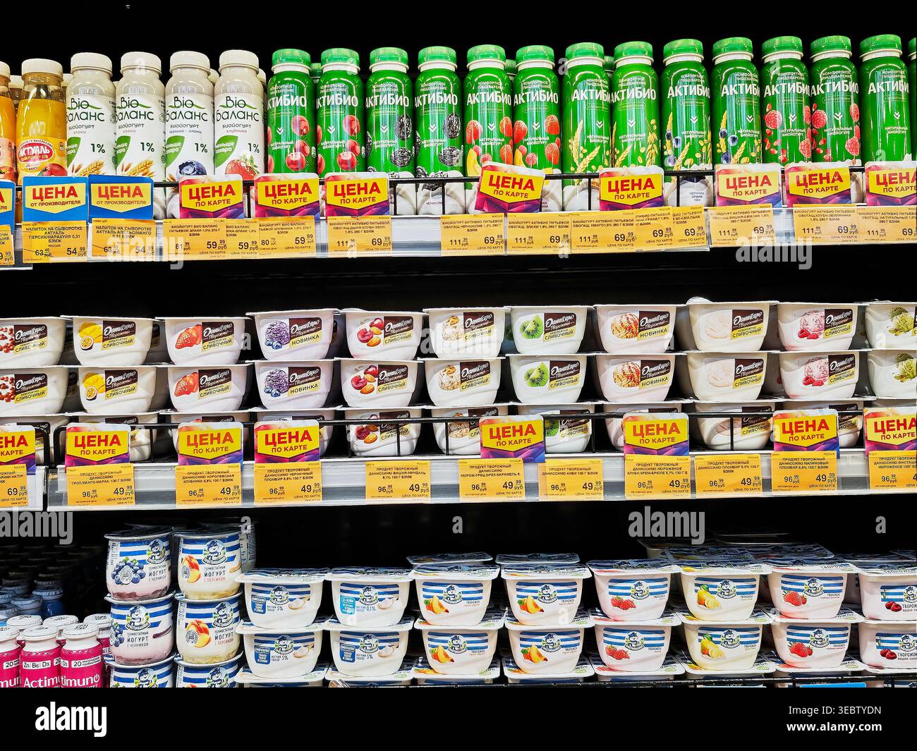 Kirov, Russia - 29 gennaio 2026: I clienti esplorano un corridoio di supermercati con scaffali che espongono yogurt e bevande. Gli acquirenti selezionano gli articoli e li controllano Foto Stock