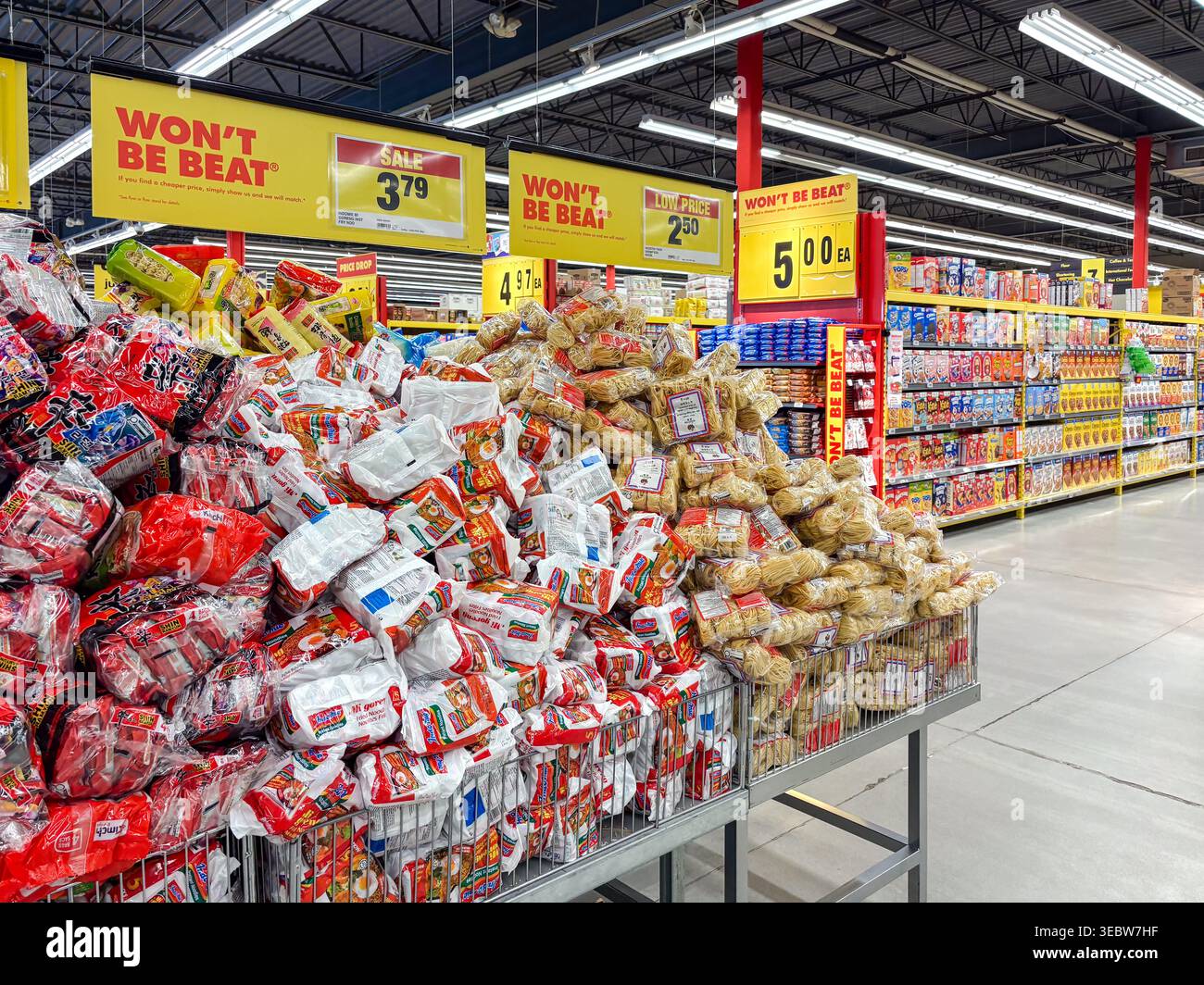 Un'ampia esposizione promozionale di vari marchi di spaghetti istantanei all'interno di una corsia del supermercato canadese, con cartelli gialli Will't Be Beat Price. Foto Stock