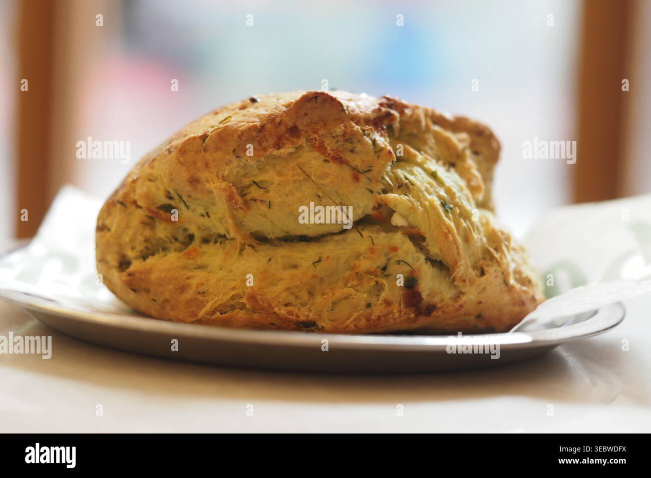Il pane appena sfornato si trova su un piatto vicino alla finestra Foto Stock