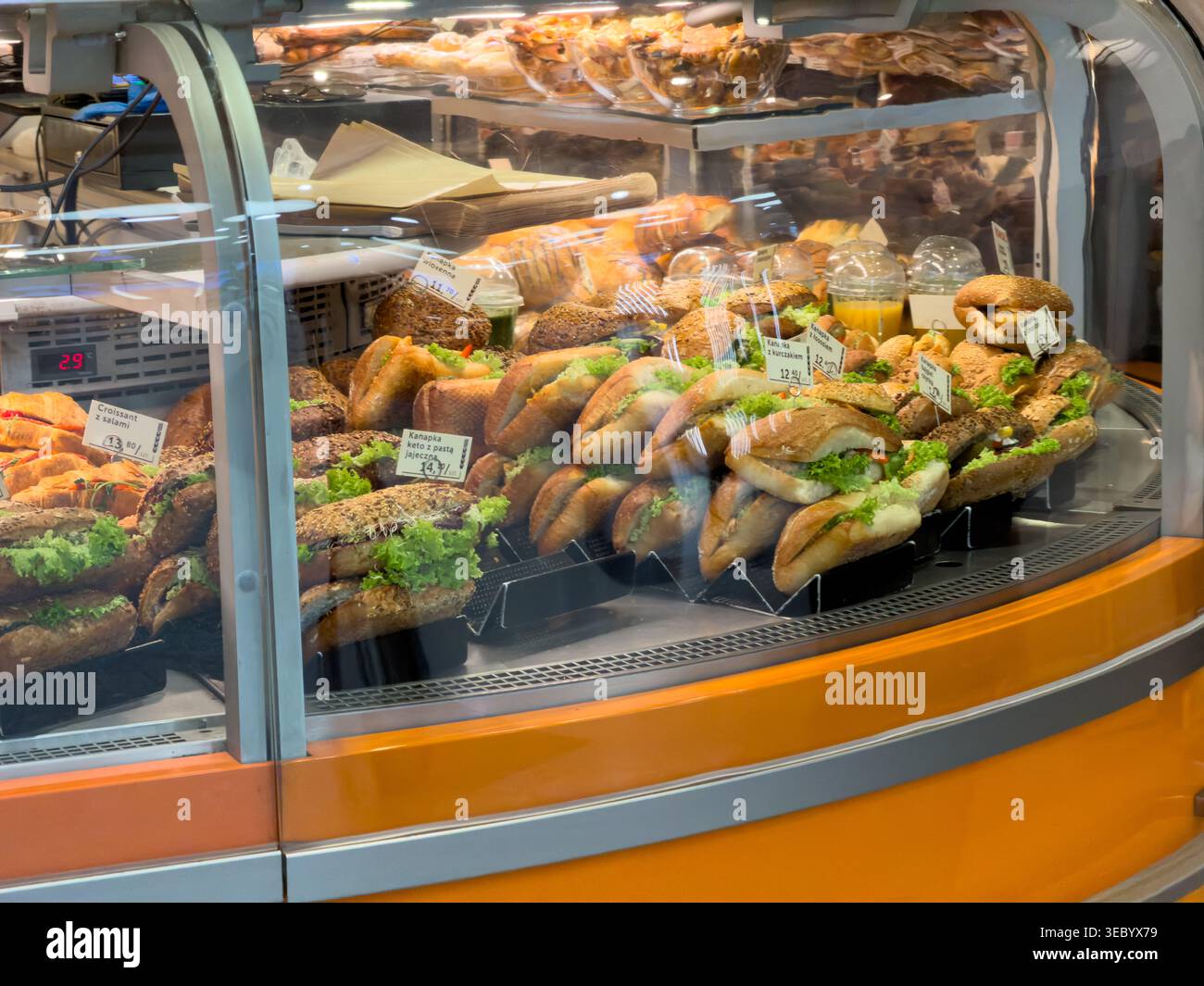 Ampia scelta di appetitosi panini e prodotti da forno presentati in una vetrina refrigerata professionale, ideale per il catering o l'acquisto d'impulso Foto Stock