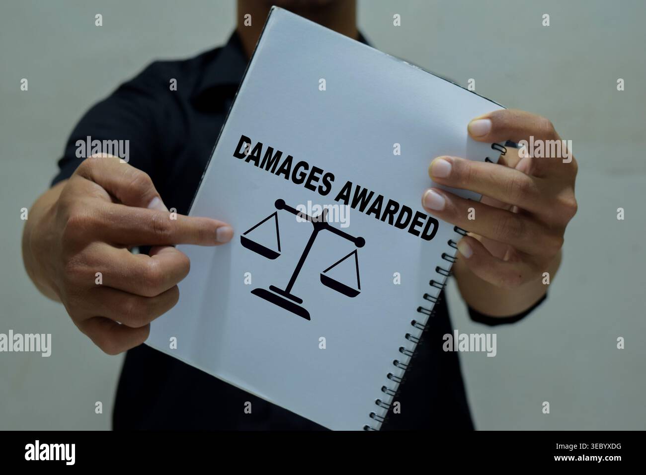 Un uomo d'affari tiene in mano un libro con il nome dei danni concessi. Foto Stock