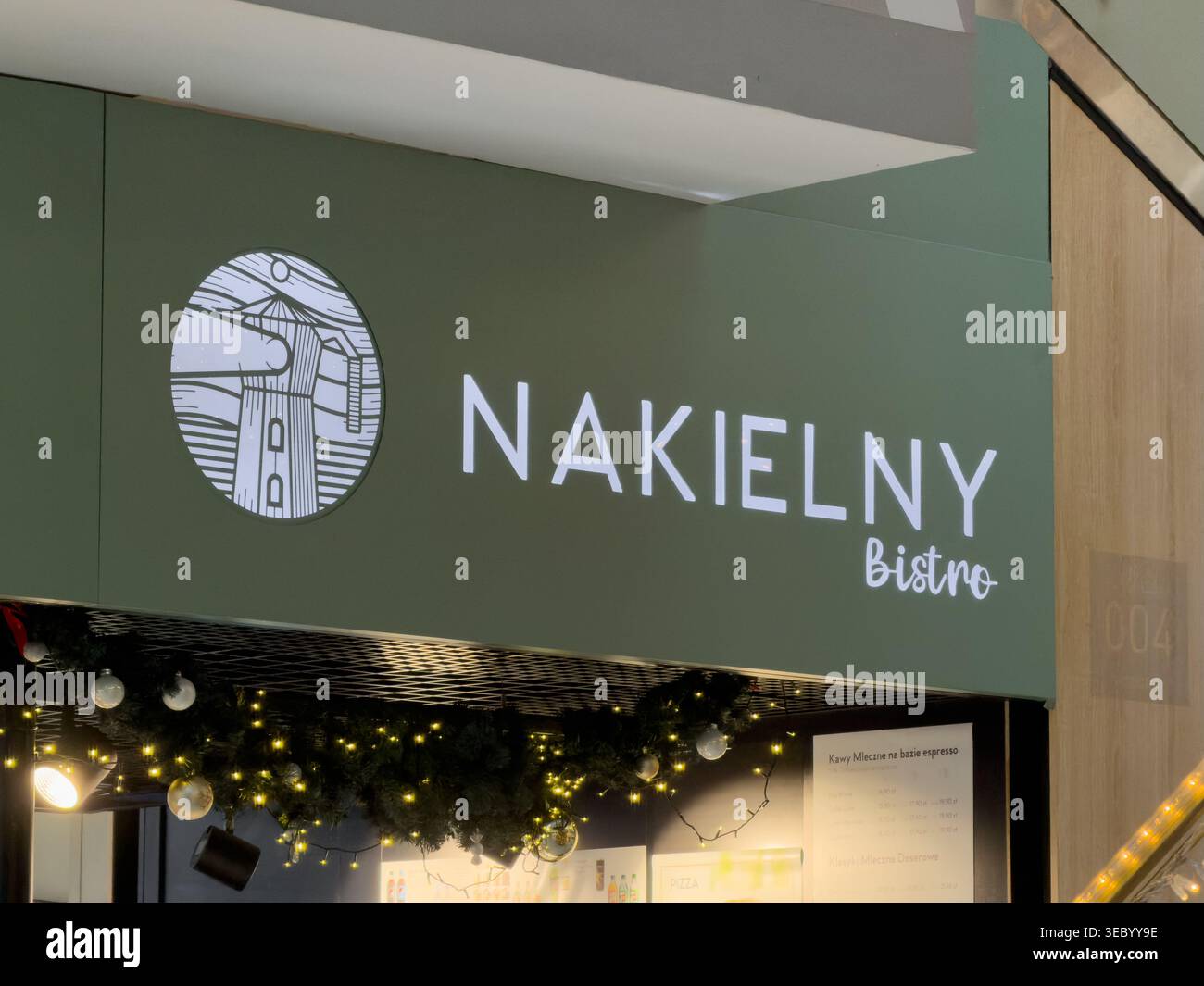 Cracovia, Polonia - 3 dicembre 2025: Vista esterna di un locale Nakielny Bistro con il suo cartello di spicco e un affascinante logo circolare illuminato Foto Stock