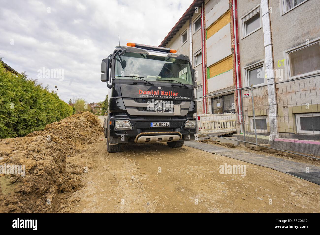 Camion nero su una strada polverosa in un'area residenziale con lavori di costruzione di edifici, ristrutturazione residenziale, Nagold, distretto di Calw, Germania Foto Stock
